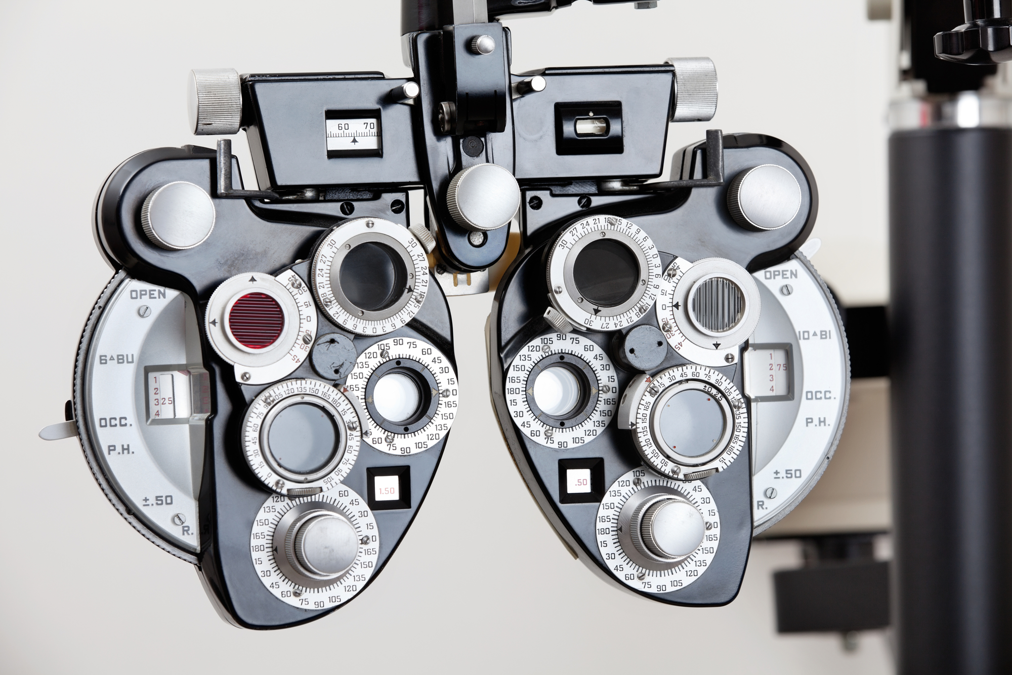 A phoropter an optical clinical testing machine or equipment pictured over a blank wall